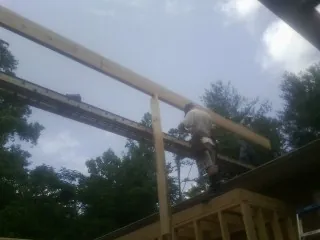 Carpenter setting a ridge beam over a new addition frame — Ice Dam Removal by Roofing Brothers in Widen