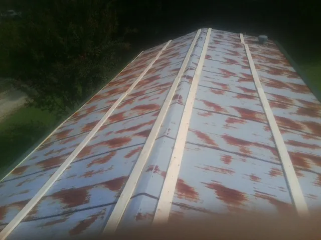 Rusted metal roof panels with new wood purlins before replacement — Storm Damage Roof Repair in Widen by Roofing Brothers
