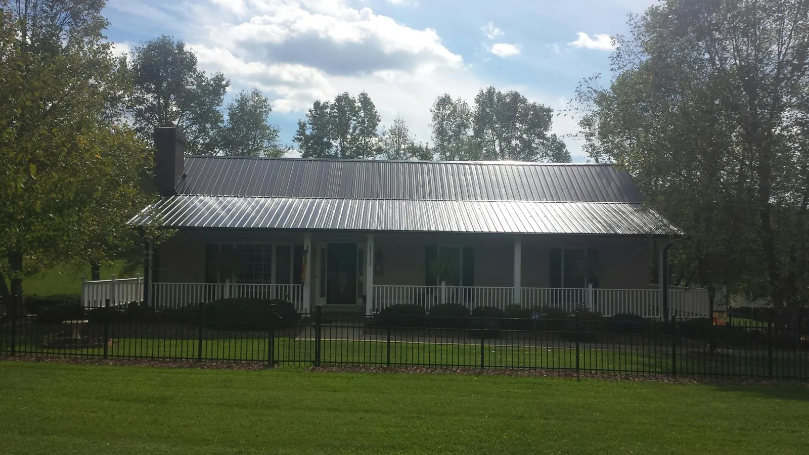 Gray metal roof on a brick ranch with a full width front porch — Gutter Guard Installation work by our crew in Widen