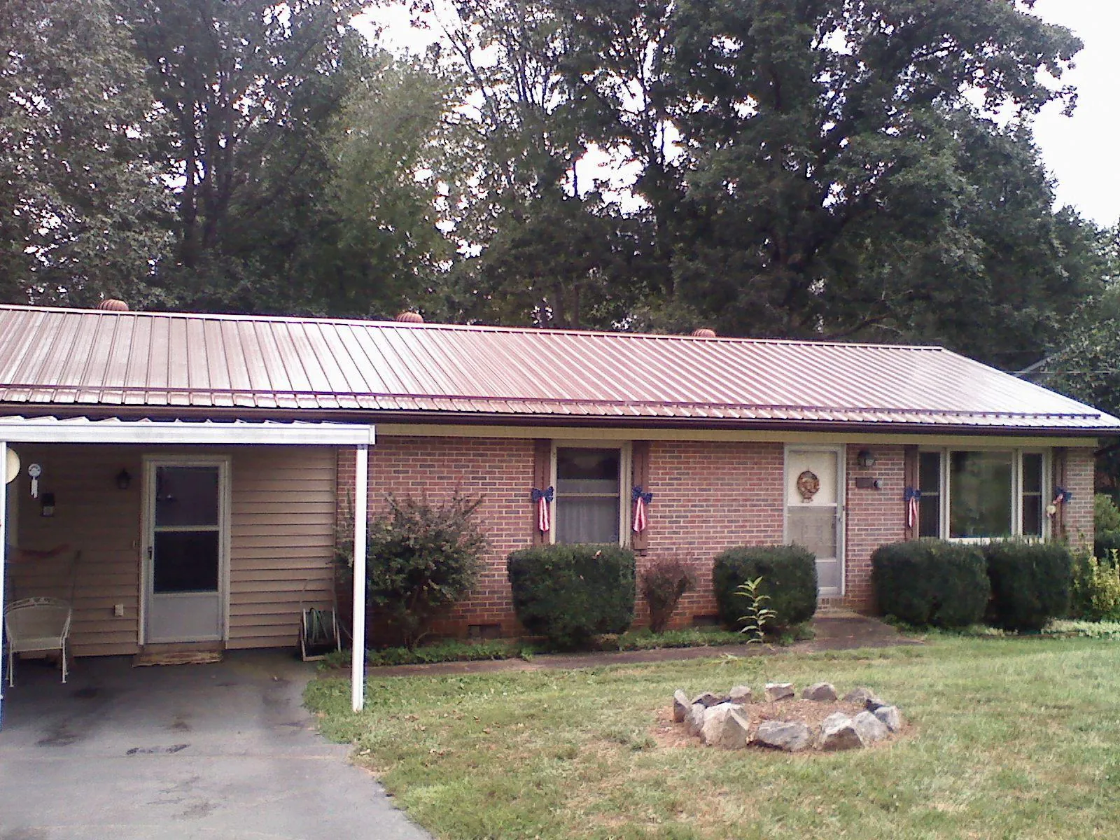 Bronze metal roof and carport on a brick ranch home — Roof Repair work by our crew in Widen